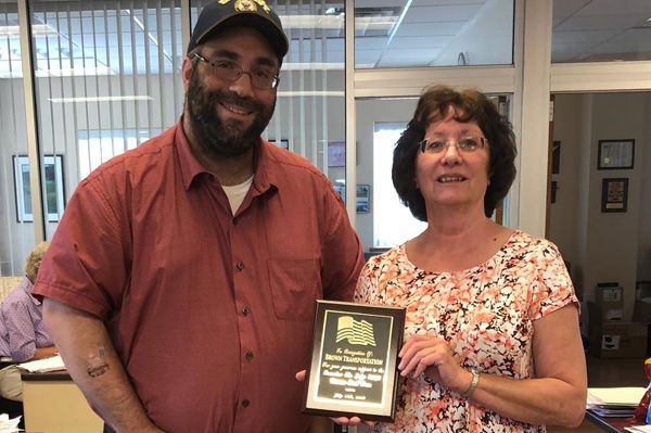 man standing next to a woman holding an office award